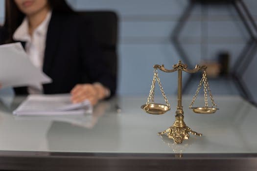 Balance scales on a desk in a professional office with a blurred businesswoman in the background.